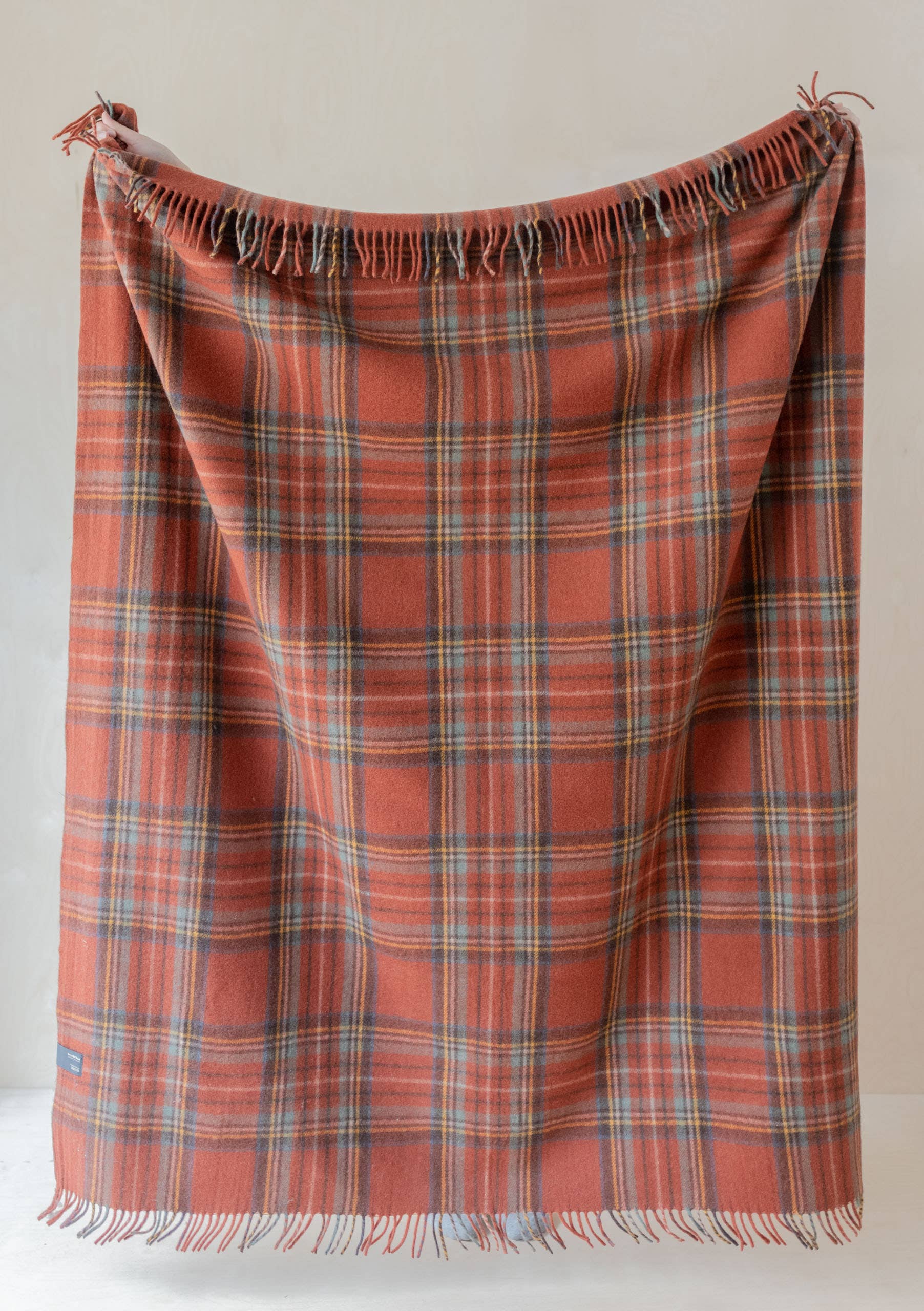 Recycled wool blanket in Stewart Royal Antique Tartan by TBCo, showcasing a cozy, tartan pattern in rich red and blue hues.